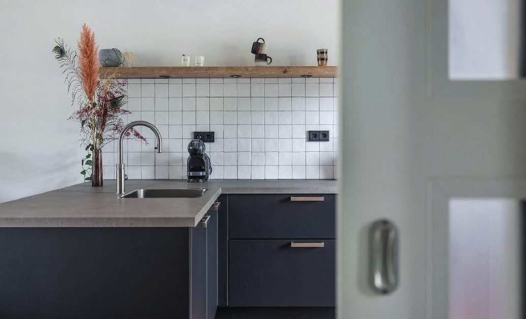 Kitchen with black fronts and a wood-look worktop, wrapped