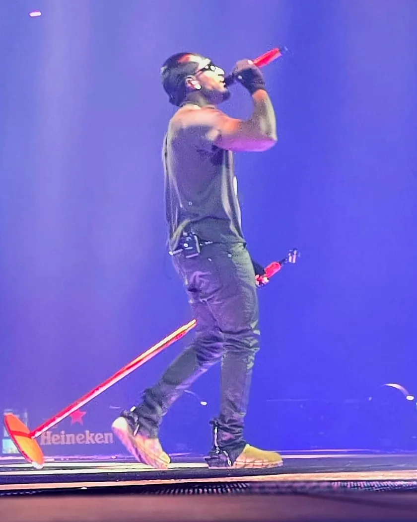 Rapper Frenna performing on stage with a red wrapped wireless Shure microphone by WRPPN