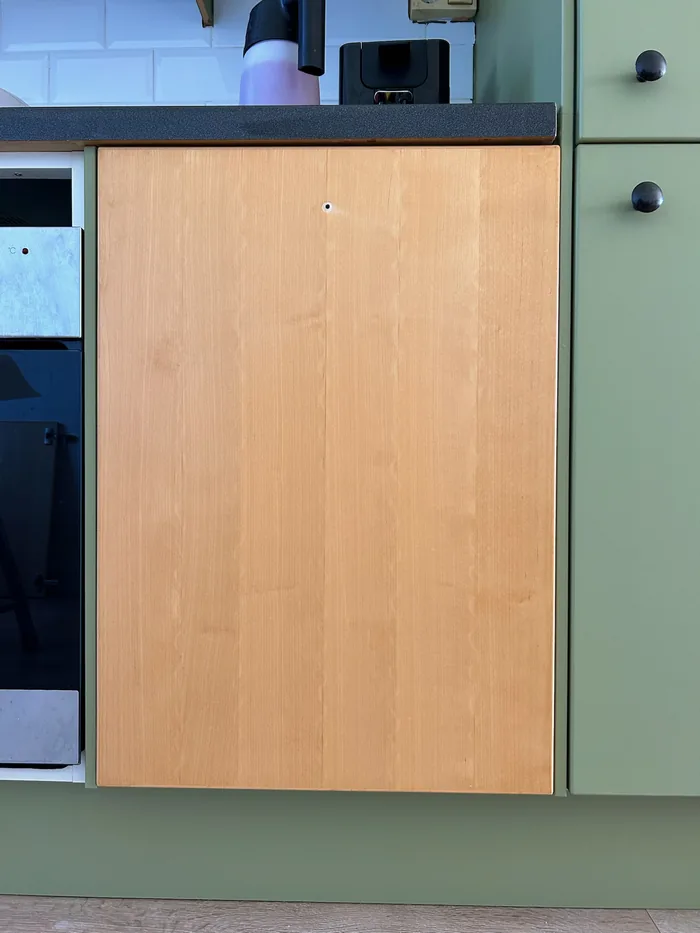 During wrapping: one wood-look door among green fronts