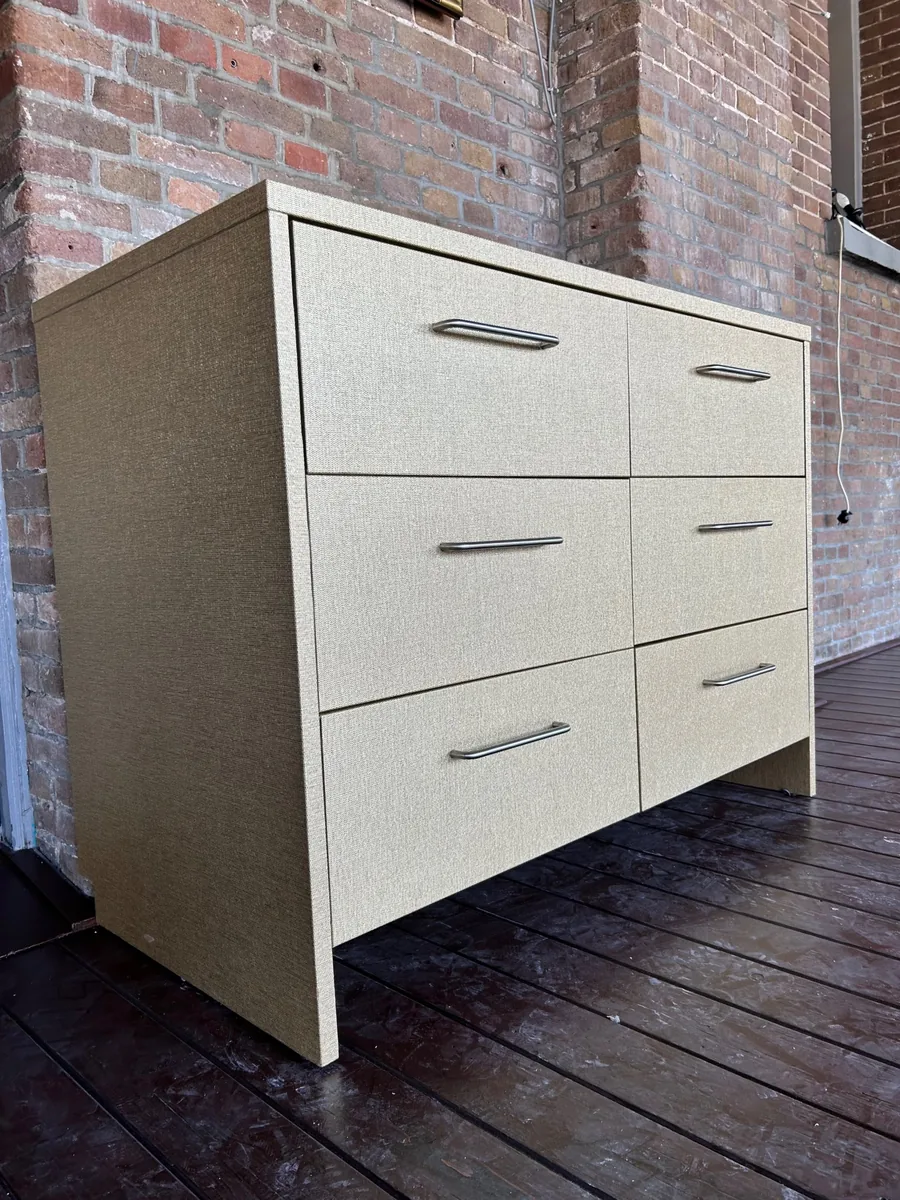 Chest of drawers wrapped in a linen look with a gold sheen, seen from the front