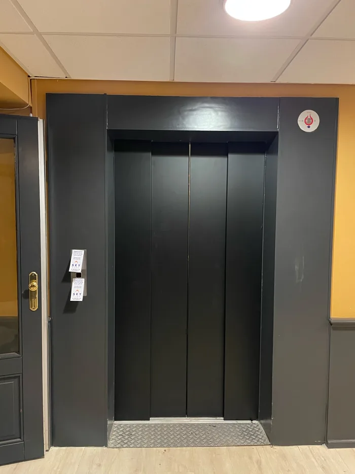 Lift doors wrapped in matt black, another angle