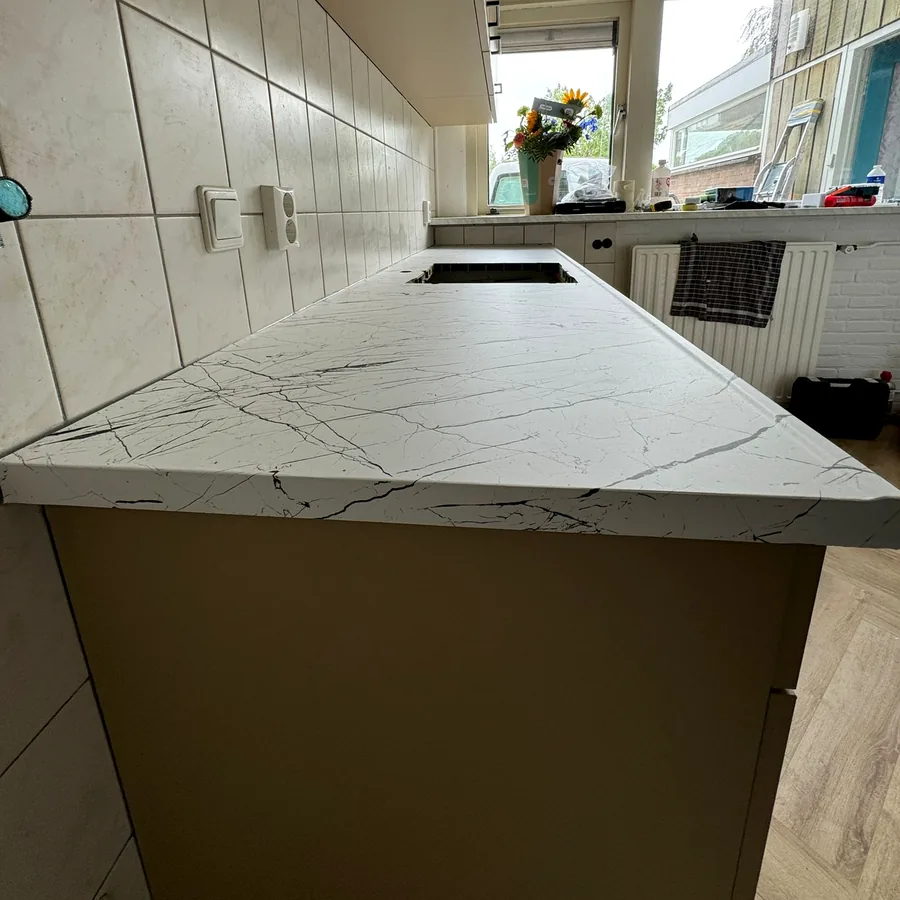 White marble-look worktop close up, with taupe cabinet fronts