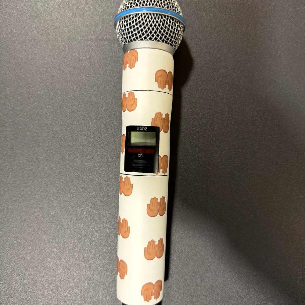 Wireless Shure microphone wrapped in a white custom print with an orange motif