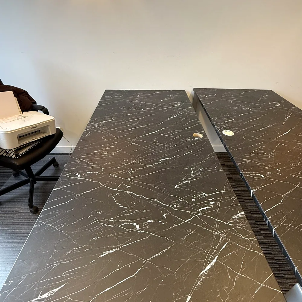 Desk tops in a black marble look with white veins, close up