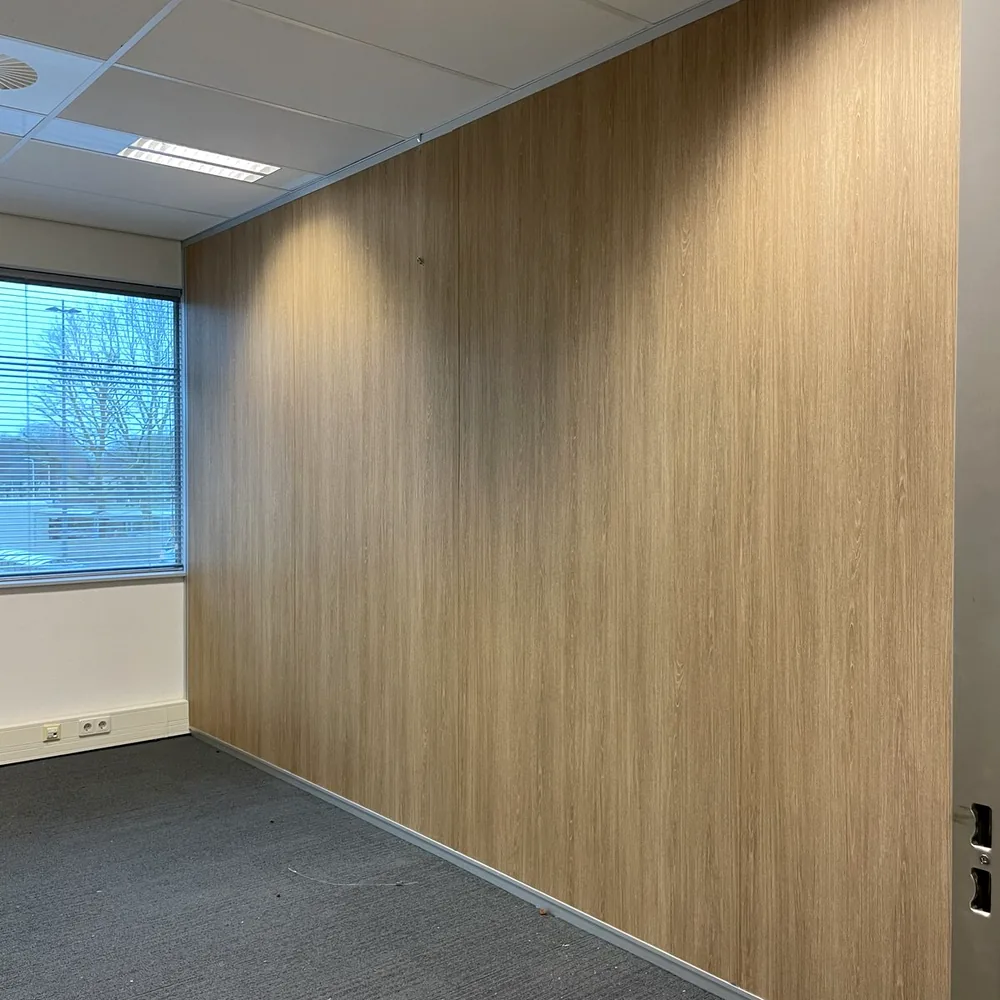 Office wall wrapped in a light wood look, with carpet and a suspended ceiling