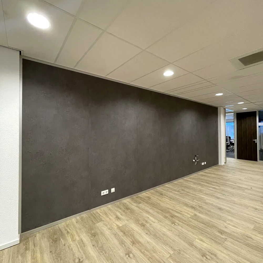 Long office wall wrapped in a dark stone look