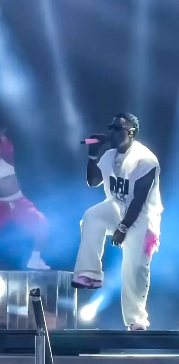 Frenna in white on stage with a matt pink microphone