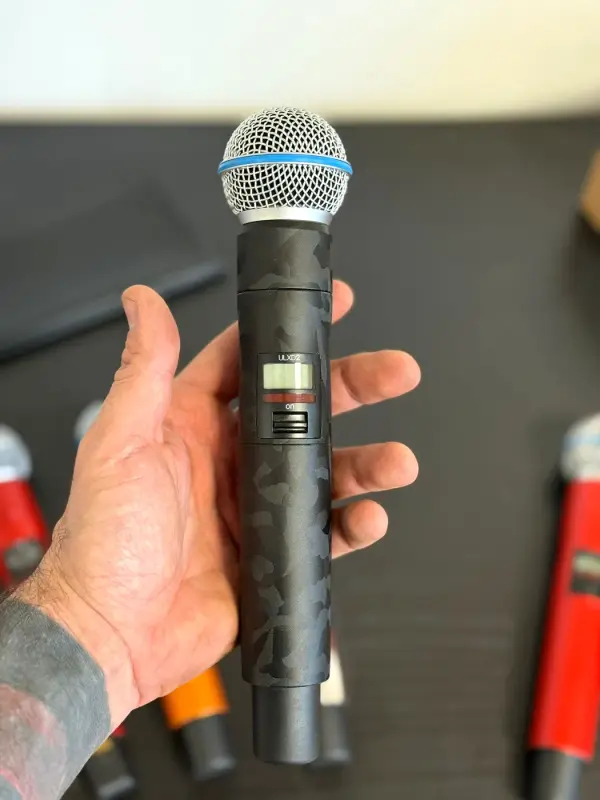 Hand with a microphone in a black camouflage print