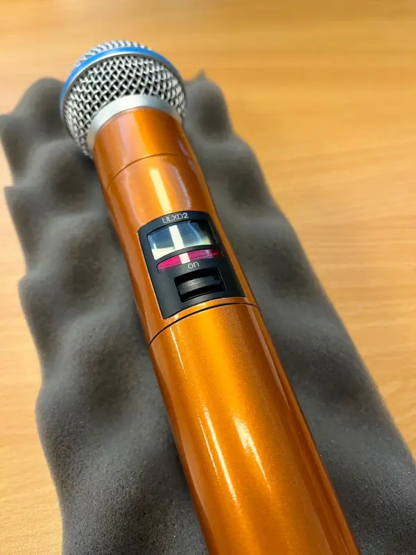 Microphone in metallic orange on grey foam