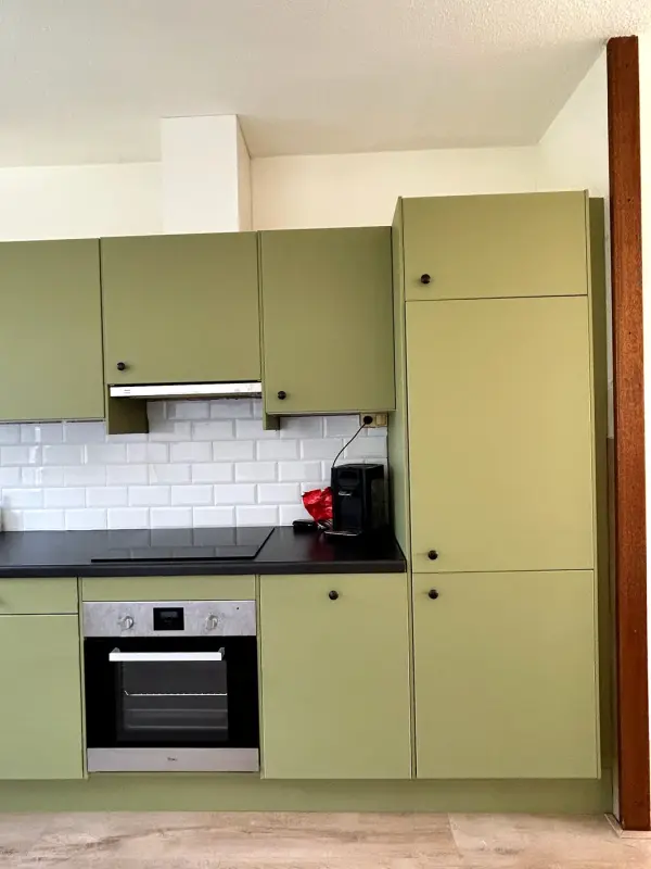 After: green cabinets with oven and tall cabinet