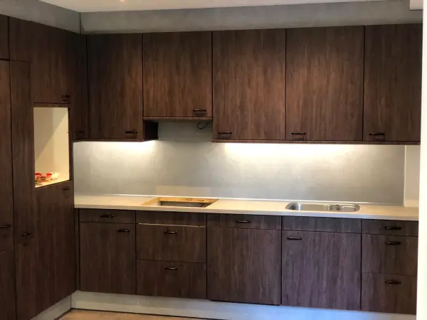 After: kitchen in dark woodgrain with lighting under the cabinets