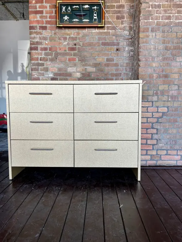Linen-look chest of drawers in front of a brick wall