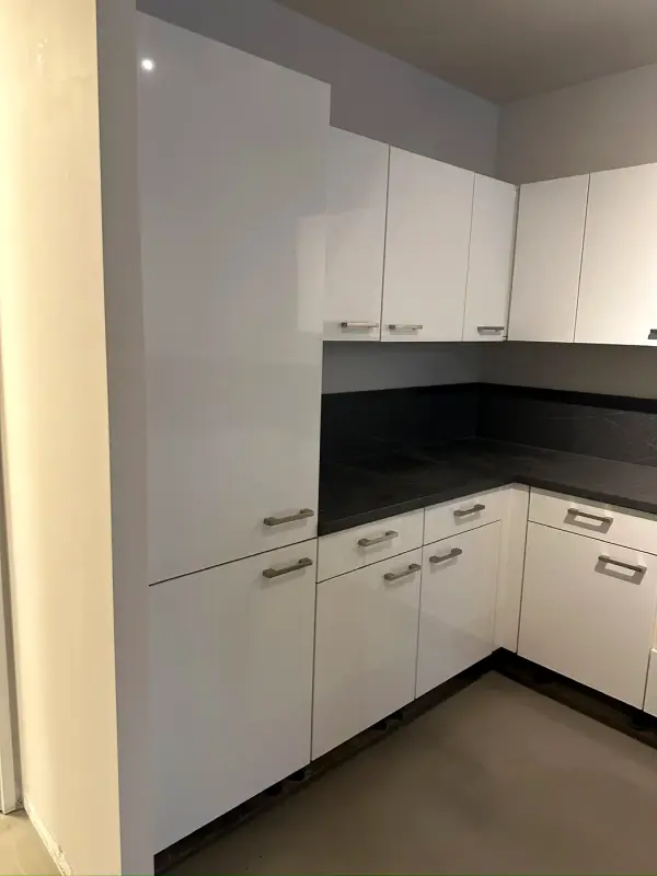 Before: corner kitchen in white with a black worktop