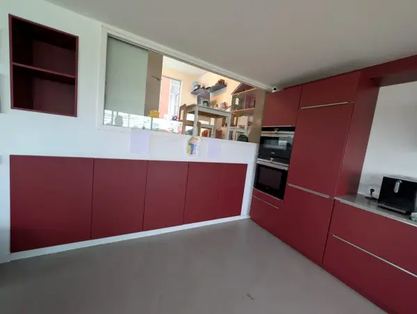 Red kitchen with a view of the living room