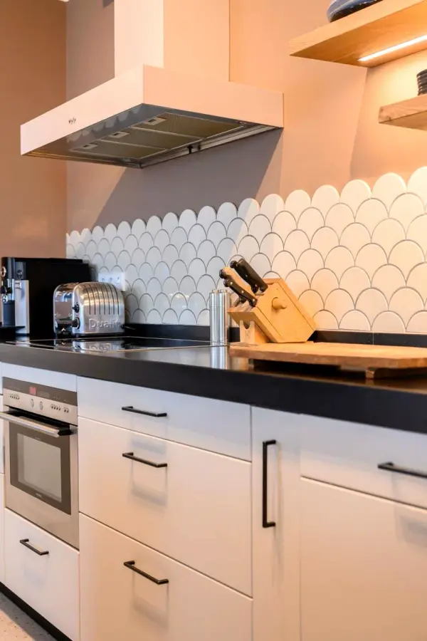 Kitchen cabinets with light pink wrapped fronts and black handles