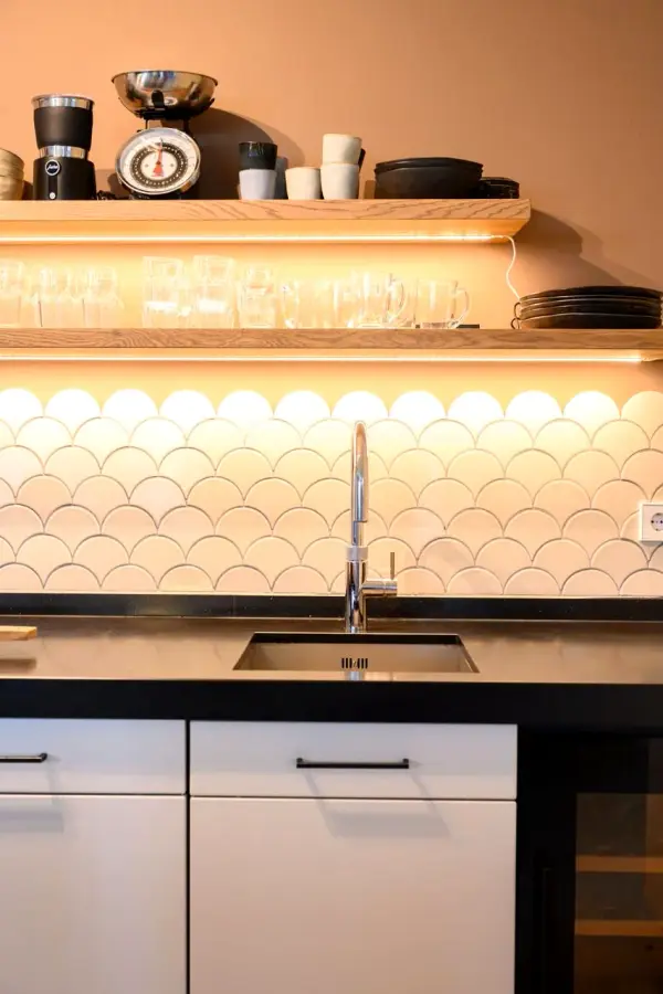 Sink under open shelves with lighting