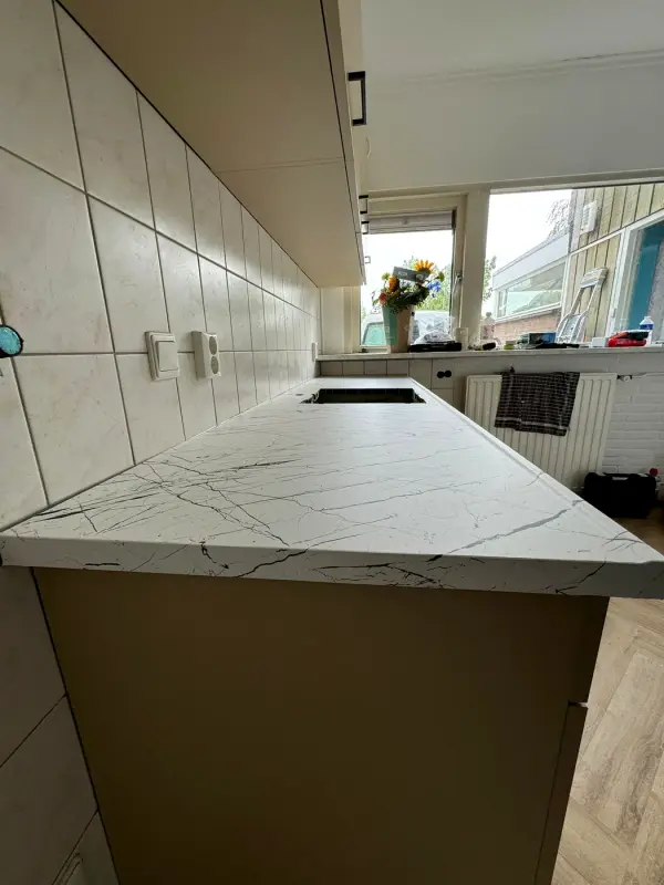 White marble-look worktop close up, with taupe cabinet fronts