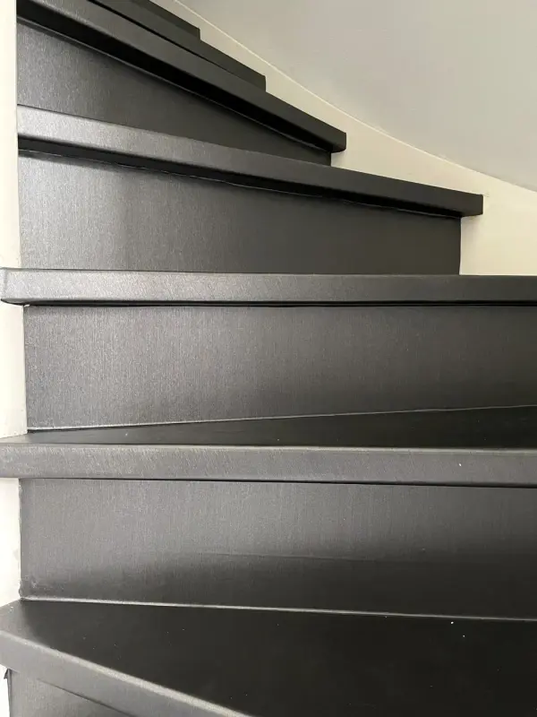 Stairs with black treads and risers, from below