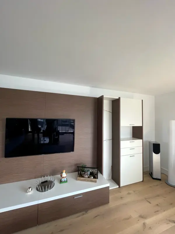TV wall with a tall white cabinet beside it