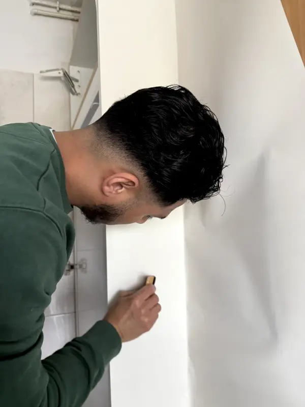 A fitter cuts white film to size with a knife