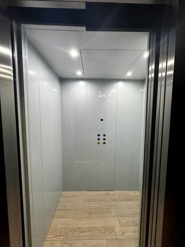 Before: lift car with grey walls, from the door