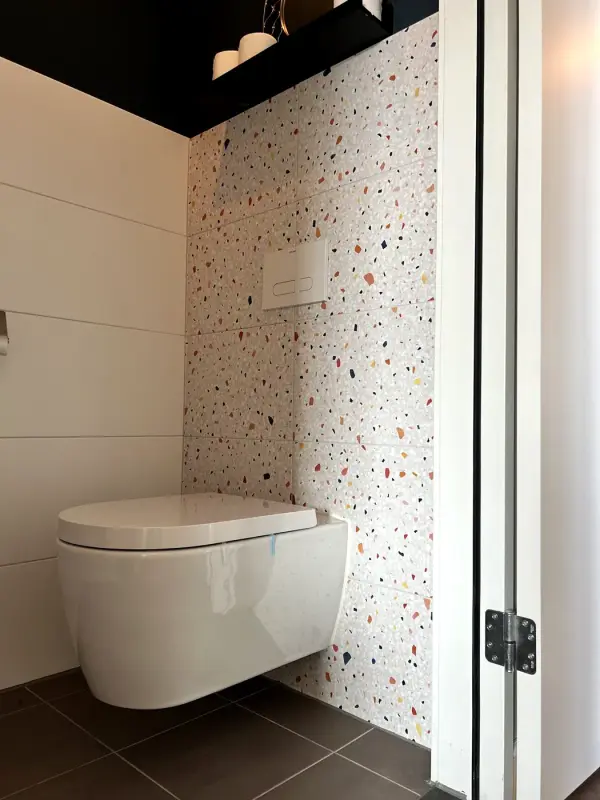During: terrazzo film above the white tiles, under the black shelf