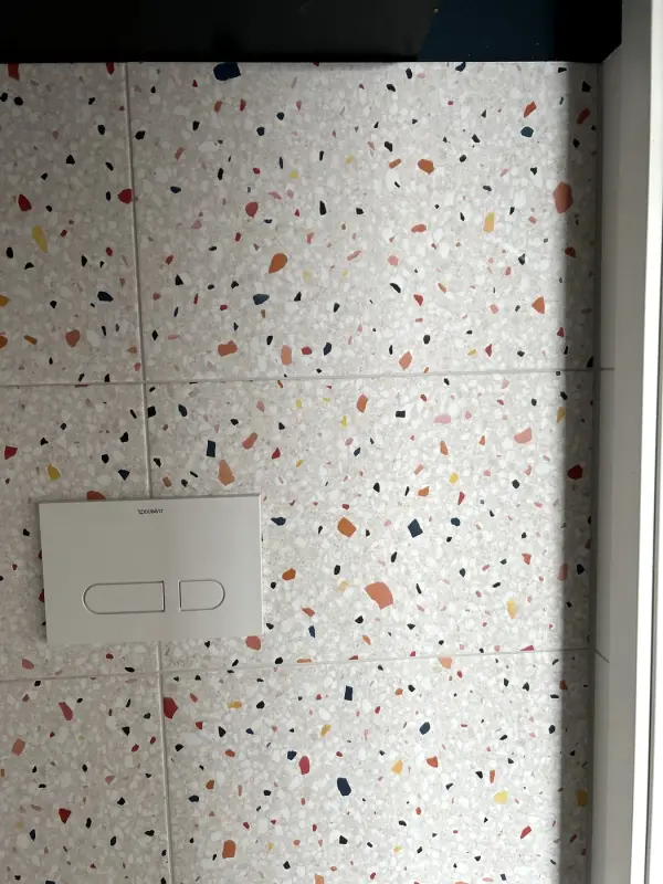 After: washroom in a terrazzo look under a black shelf
