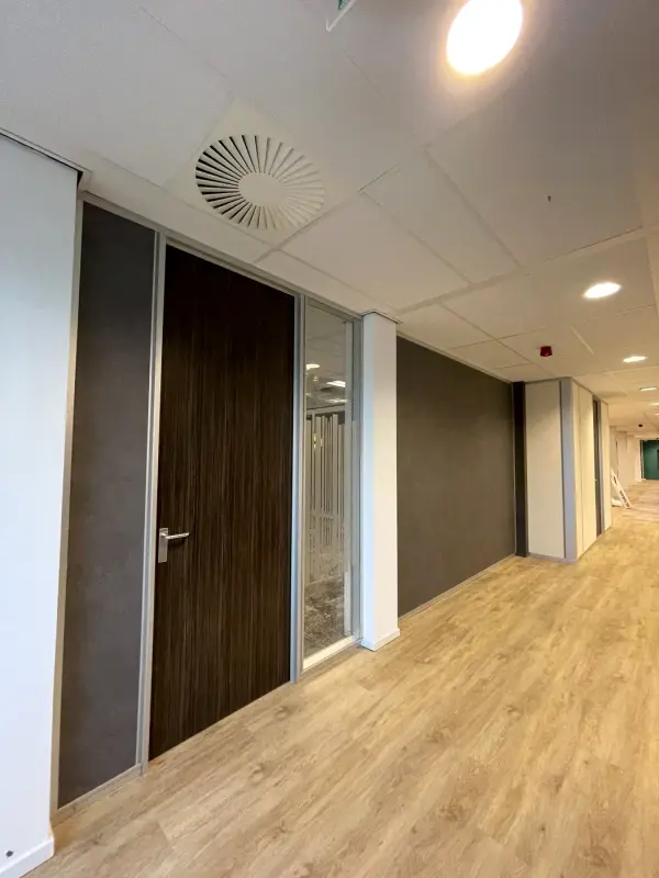 Dark stone-look wall next to a corridor and windows